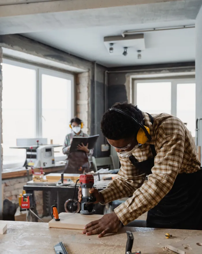 A carpenter carefully shaping wood in a workshop